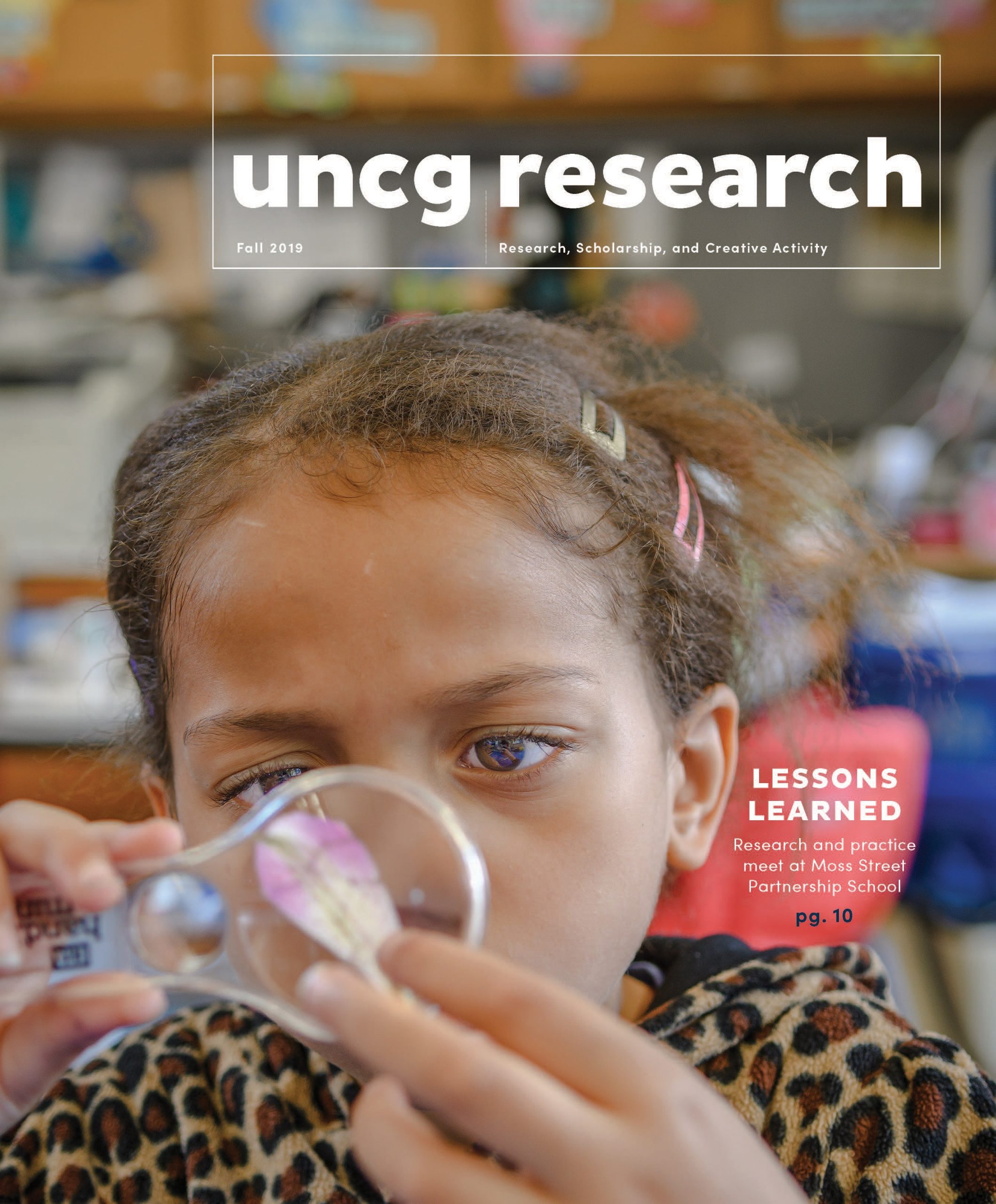 a young person examines a flower pedal through a magnifying glass