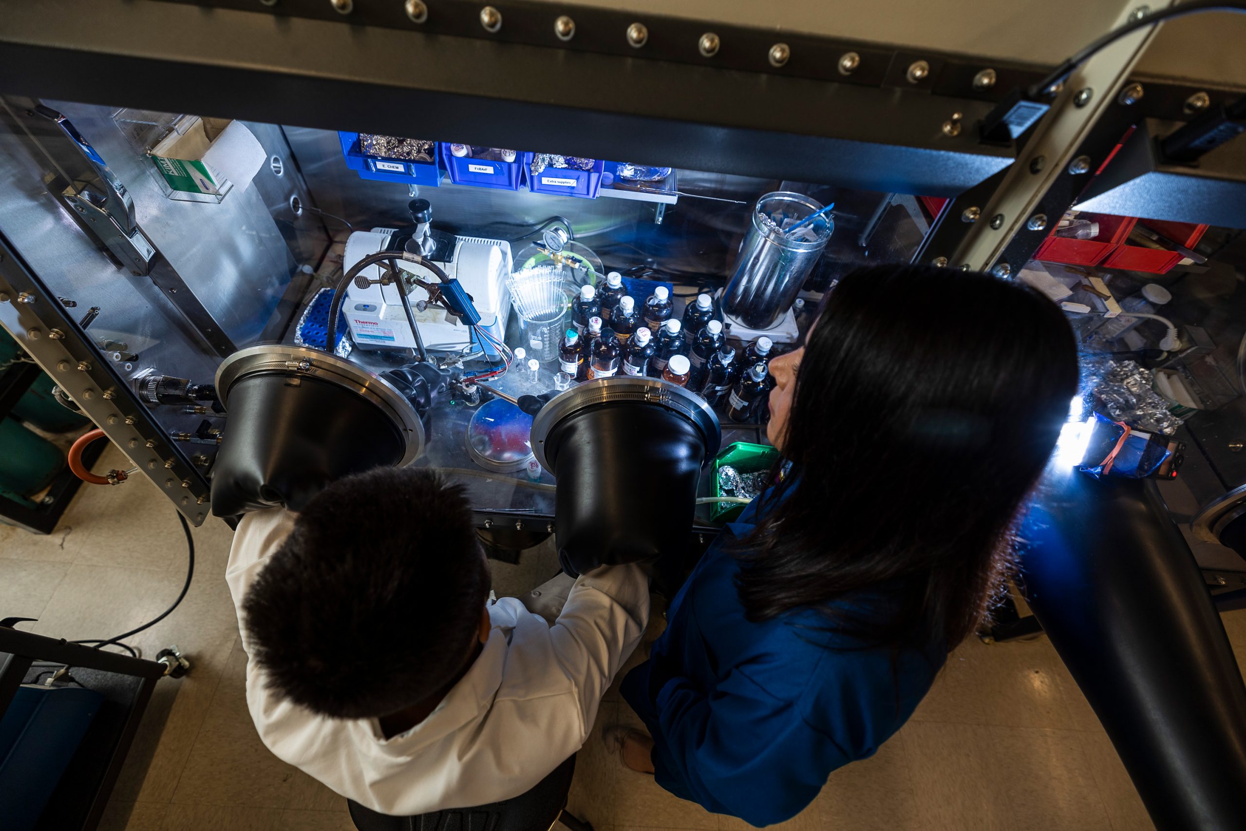 Two people in lab coats working in a lab