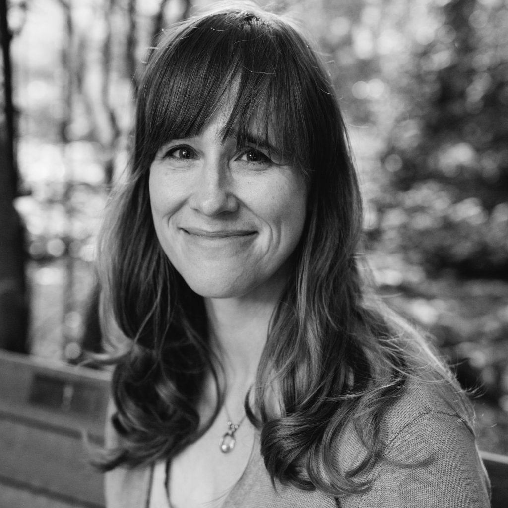 black and white photo of a woman looking at a camera