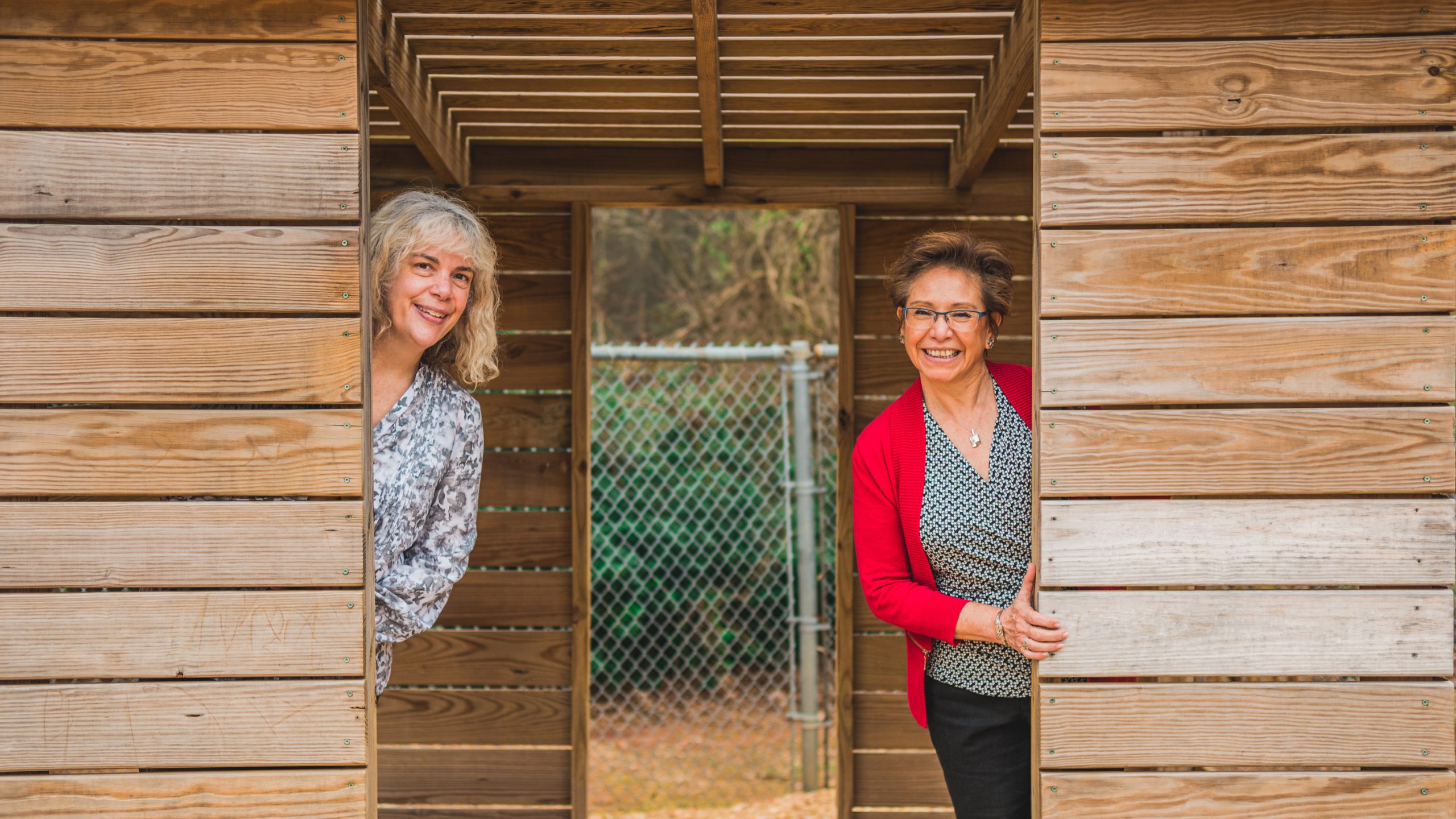 two women standing in a wooden structure
