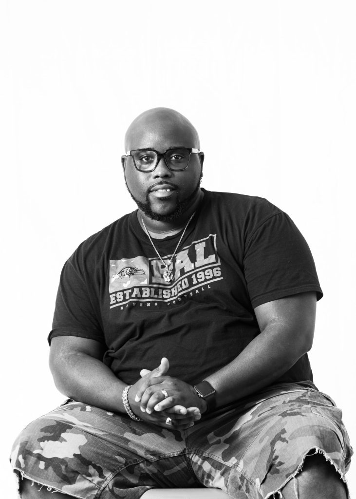 a man wearing glasses sitting on a chair