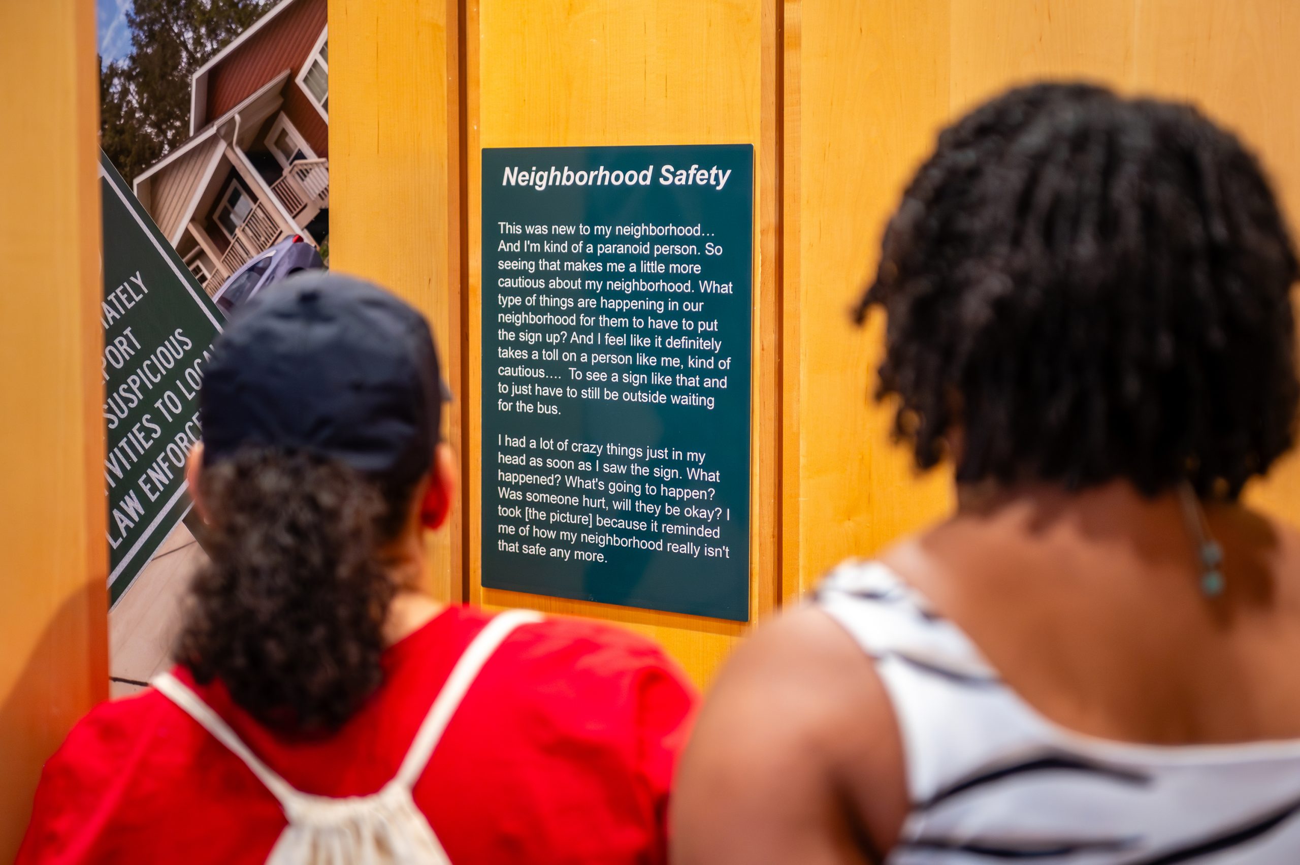 Students observing the exhibit "Neighborhood Safety" at Youth Mental Health Photovoice project