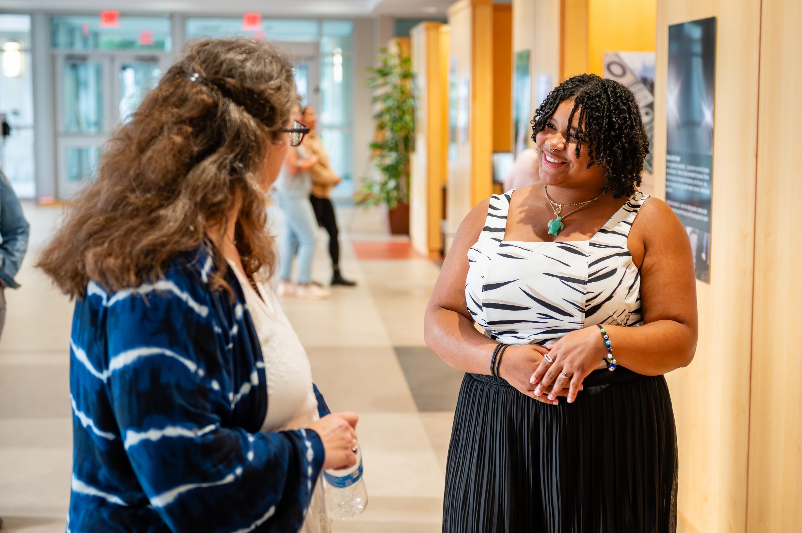 Two people speaking about art at the Youth Mental Health Photovoice Exhibit