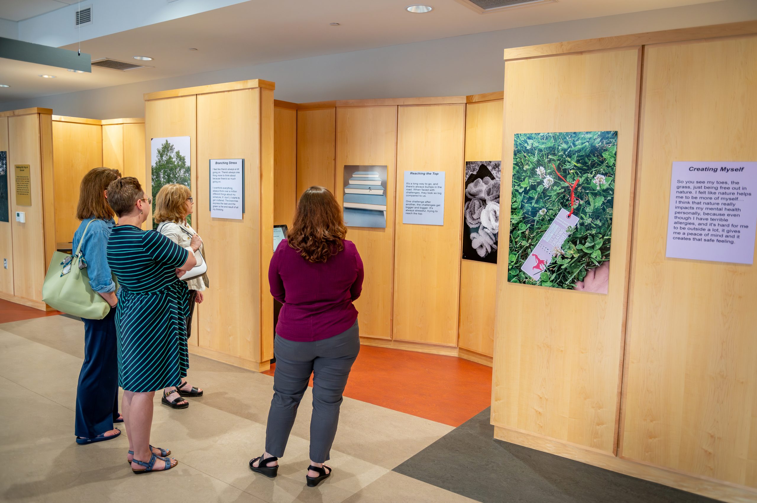 People looking at student exhibits for the Youth Mental Health Photovoice