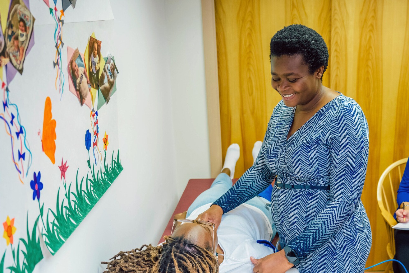 Dr. Forgive Avorgbedor demonstrating the use of a Vicorder, a device to assess arterial stiffness on PhD student Favour Omondi